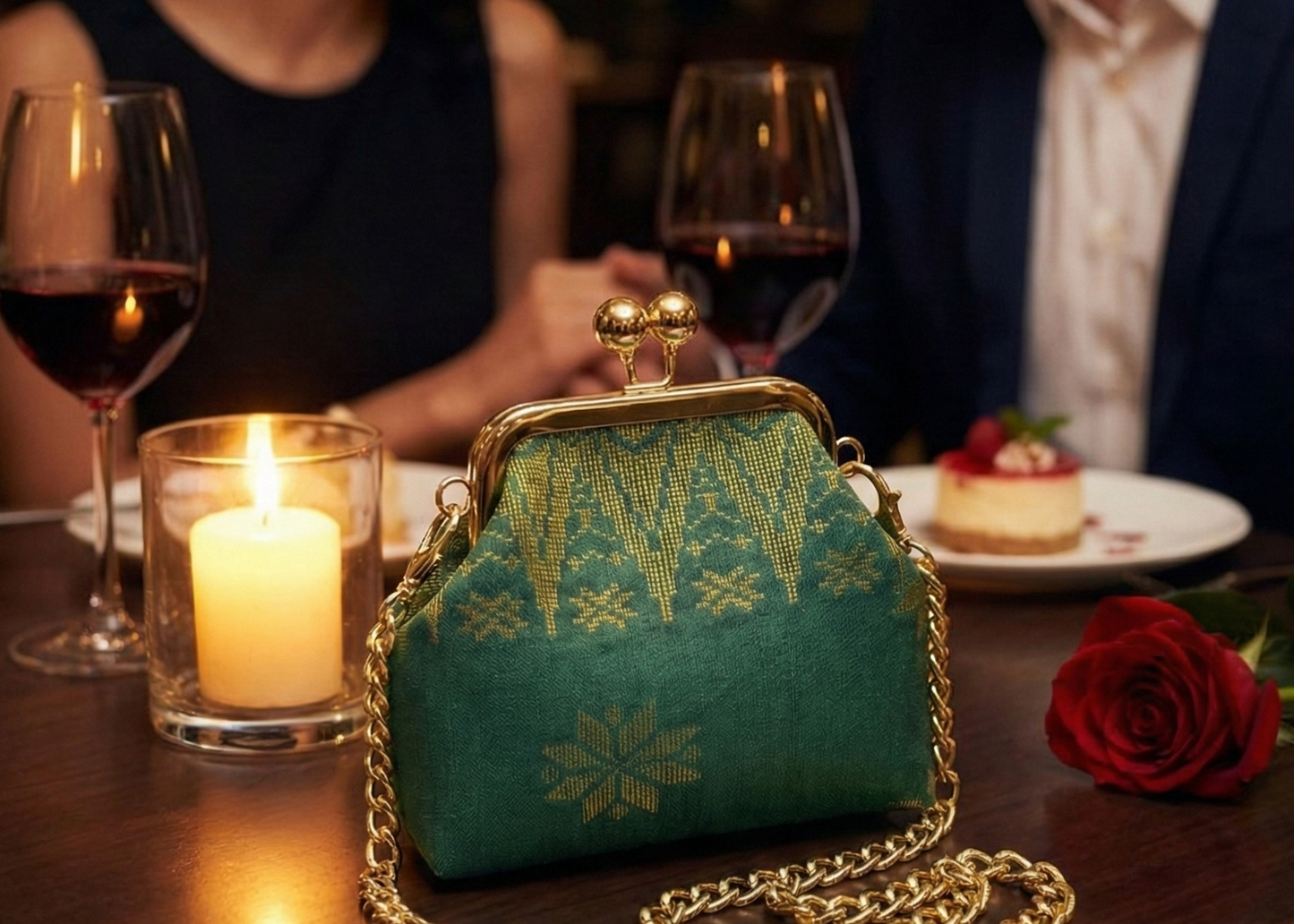Teal handbag with gold chain on a table with a couple dining in the background