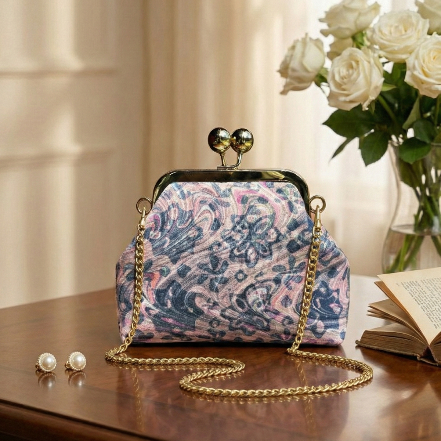 Floral patterned handbag on a wooden surface with flowers and jewelry in the background